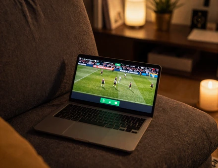 Smartphone auf dem Sofa streamt bei Nacht ein Live-Fu&szlig;ballspiel mit limefarbener UI im Golazzo Sportsbook