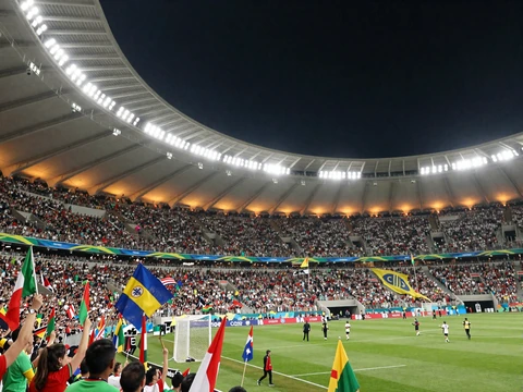 WM-2026-Stadion mit jubelnder Menge und Fahnen unter Flutlicht f&uuml;r Fu&szlig;ball-Live-Wetten bei Golazzo